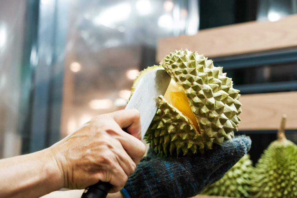 An image of a person cutting open a scrumptious durian